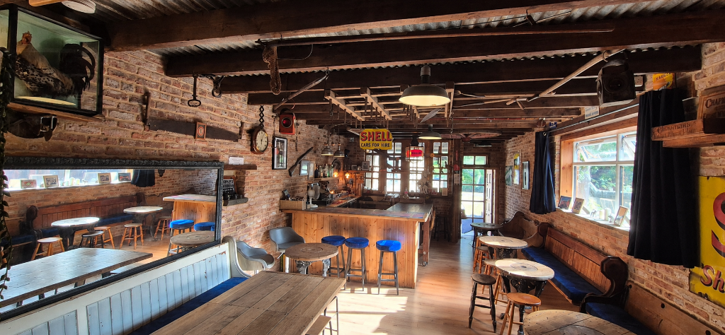 The Barn interior with exposed brick, wooden beams, communal table and vintage signage